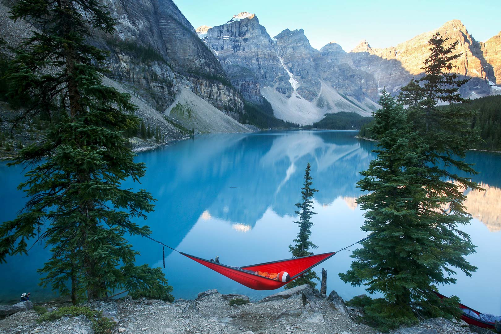 Picture of a visitor resting in a hammock near Moraine Lake, Banff National Park, Canada