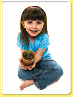Photograph shows a little girl holding a potted plant