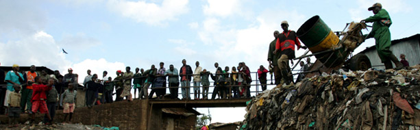 Photo: a drum of excrement is emptied into an open sewer in the Kibera slums of Kenya, Nairobi